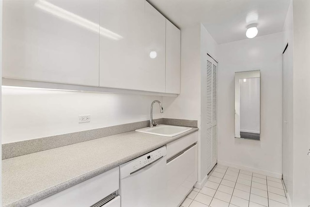 kitchen with a sink, white dishwasher, and white cabinets