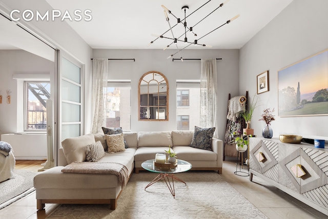 tiled living area with healthy amount of natural light and a chandelier