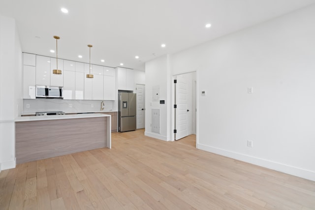 45-29 47th St Unit 2-B, New York City, NY 11377 - kitchen featuring stainless steel appliances, modern cabinets, white cabinets, light wood-type flooring, and light countertops