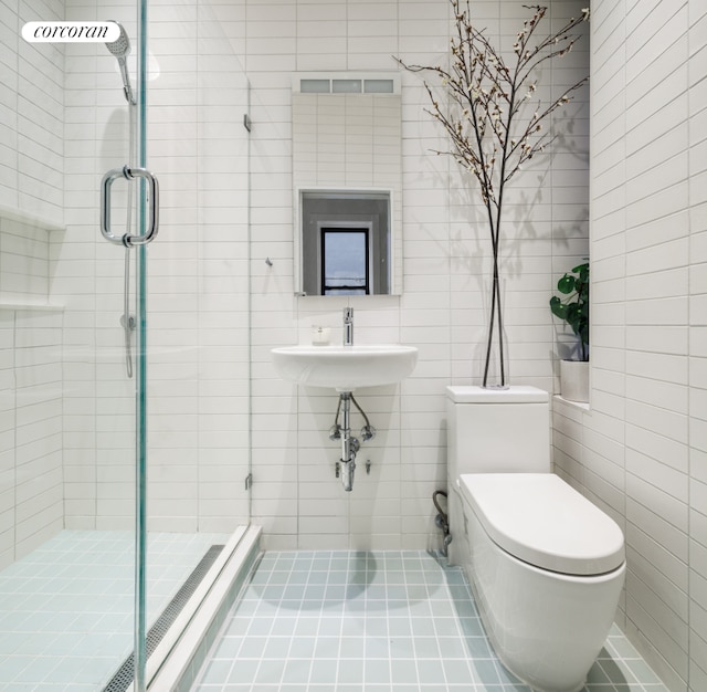 855 9th Ave Unit 1B, New York City, NY 10019 - bathroom featuring a shower stall, a sink, toilet, and tile walls