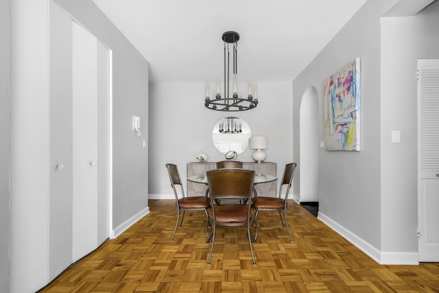 301 E 48th St Unit 14J, New York City, NY 10017 - dining room with baseboards, arched walkways, and a chandelier