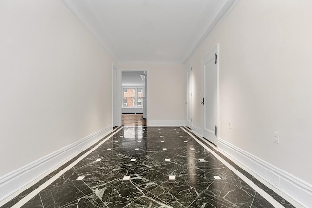 hallway with baseboards, ornamental molding, and marble finish floor