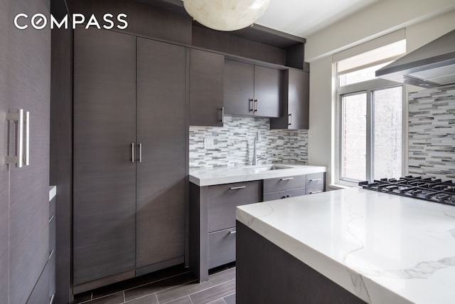 715 Park Ave Unit 11A, New York City, NY 10021 - kitchen featuring island exhaust hood, backsplash, gray cabinetry, and light stone countertops