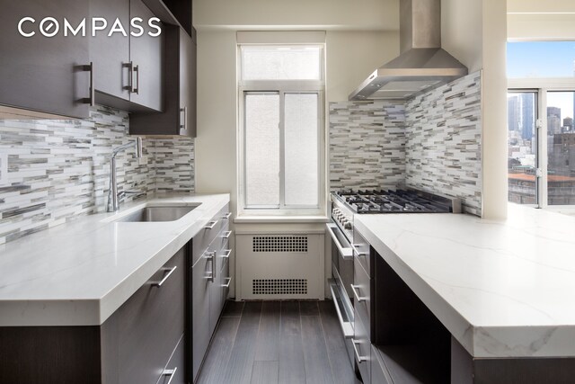 715 Park Ave Unit 11A, New York City, NY 10021 - kitchen featuring wall chimney range hood, high end stainless steel range, dark wood-style floors, light stone countertops, and tasteful backsplash