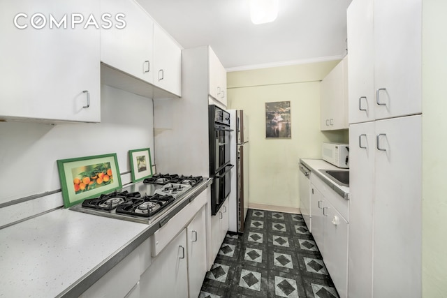 345 E 56th St Unit 5C, New York City, NY 10022 - kitchen with white appliances, dark floors, white cabinets, light countertops, and ornamental molding