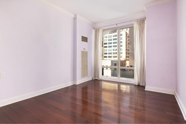 empty room with visible vents, ornamental molding, baseboards, and wood finished floors