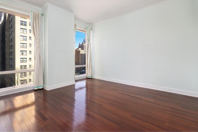unfurnished room featuring baseboards, ornamental molding, dark wood-style floors, and a view of city