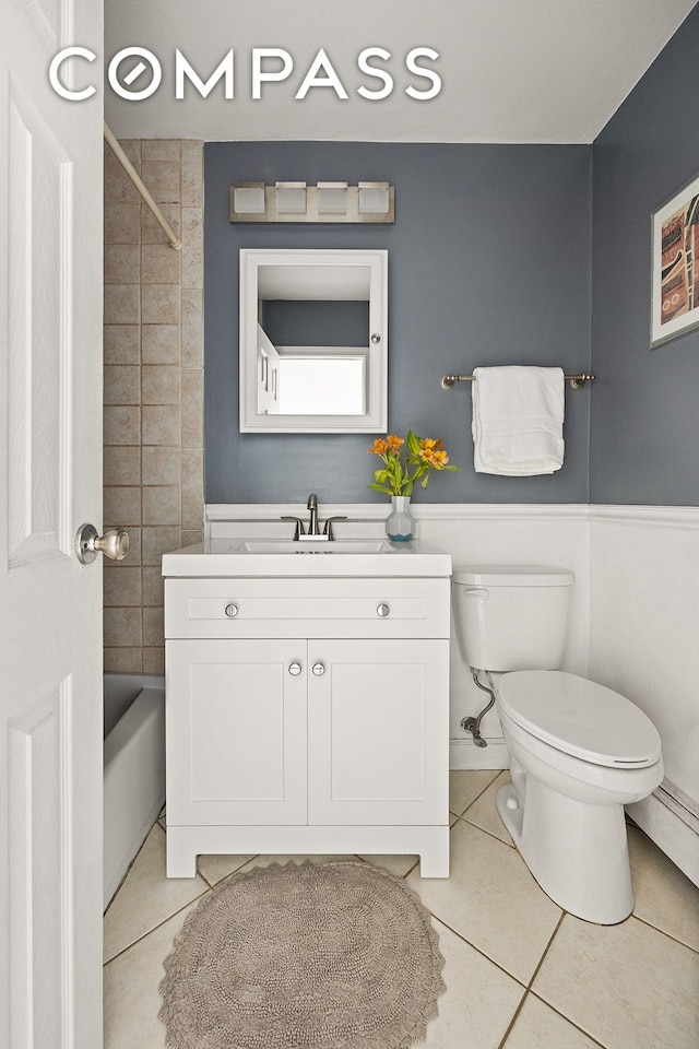 bathroom featuring tile patterned flooring, toilet, bathtub / shower combination, and vanity
