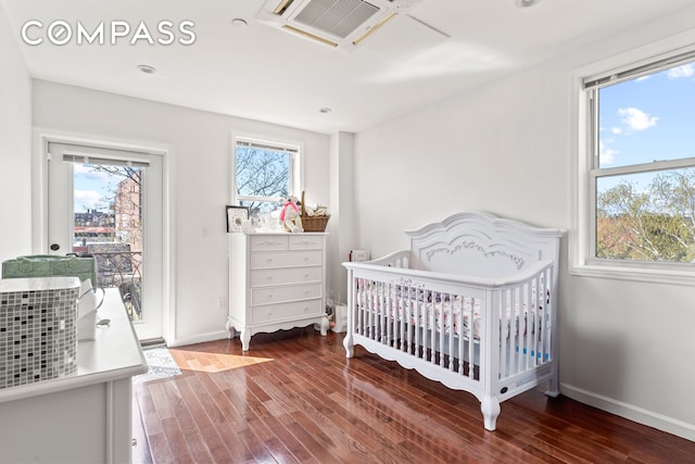 bedroom with visible vents, baseboards, and wood finished floors