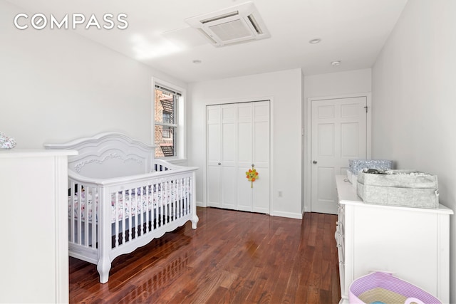 bedroom featuring a closet, wood finished floors, visible vents, and baseboards