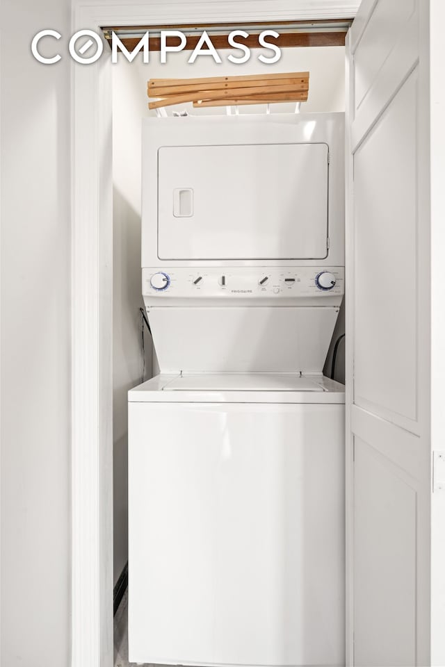 washroom with stacked washing maching and dryer and laundry area