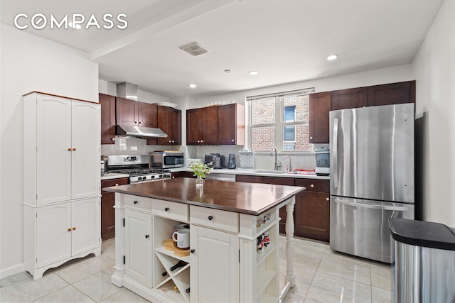 kitchen with under cabinet range hood, open shelves, light tile patterned floors, a center island, and appliances with stainless steel finishes