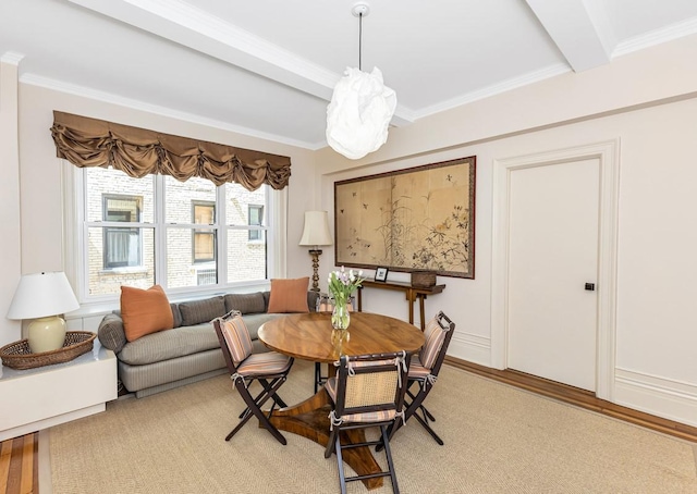 dining room with light wood-type flooring, beamed ceiling, and crown molding