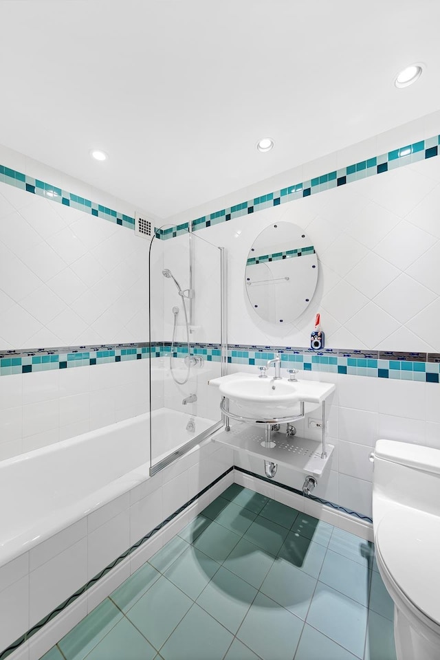 45 Sutton Pl S Unit 11K, New York City, NY 10022 - full bath with tile walls, tiled shower / bath combo, toilet, recessed lighting, and tile patterned floors
