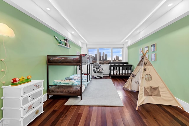 bedroom featuring dark wood-style flooring, recessed lighting, and a skyline view