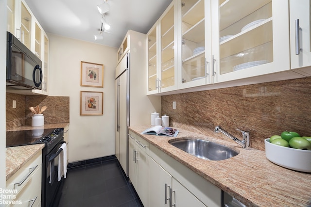 175 E 62nd St Unit 8B, New York City, NY 10065 - kitchen with black appliances, a sink, backsplash, dark tile patterned flooring, and glass insert cabinets