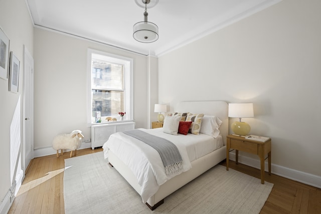 bedroom featuring radiator, baseboards, and wood finished floors