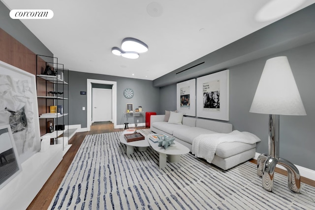 living room featuring baseboards, wood finished floors, and visible vents