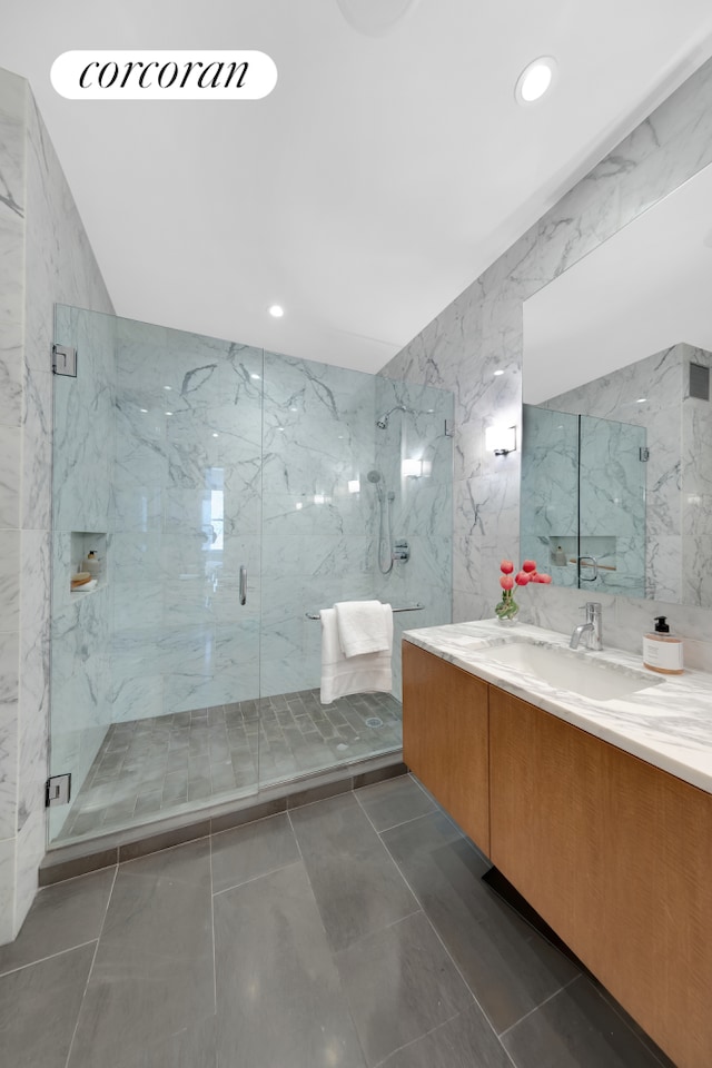 full bath with a marble finish shower, vanity, and recessed lighting