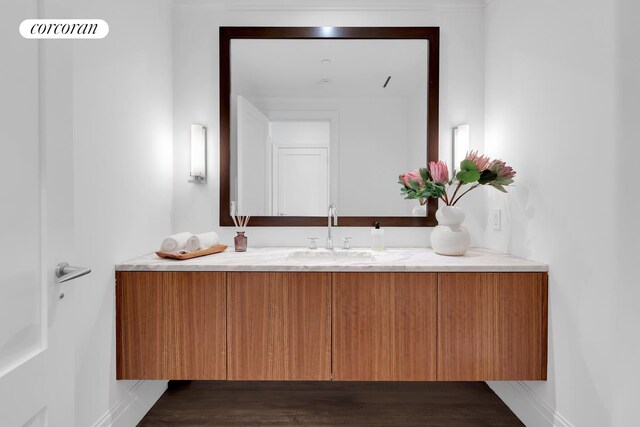 bathroom with vanity, baseboards, and wood finished floors