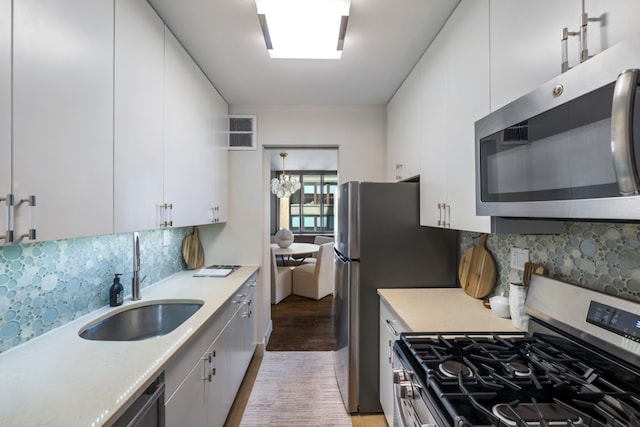 108 5th Ave Unit 8B, New York City, NY 10011 - kitchen with appliances with stainless steel finishes, light wood-style floors, light countertops, white cabinets, and tasteful backsplash