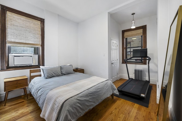 120 E 85th St Unit 2-E, New York City, NY 10028 - bedroom with multiple windows, radiator heating unit, and wood finished floors