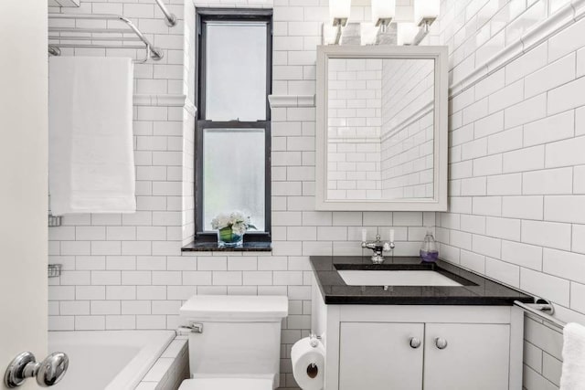 full bathroom featuring tile walls, a tub, vanity, toilet, and backsplash