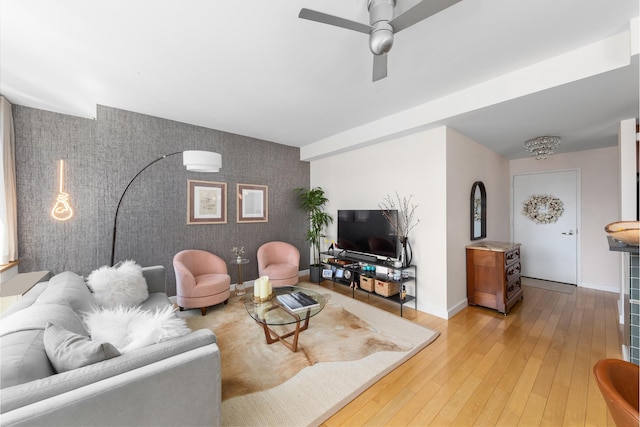 225 W 60th St Unit 14F, New York City, NY 10023 - living room with an accent wall, wallpapered walls, baseboards, light wood finished floors, and ceiling fan