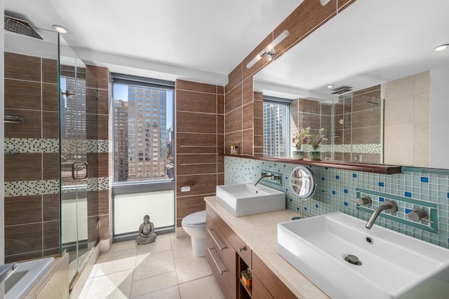 225 W 60th St Unit 14F, New York City, NY 10023 - bathroom with tile walls, healthy amount of natural light, backsplash, a shower stall, and toilet