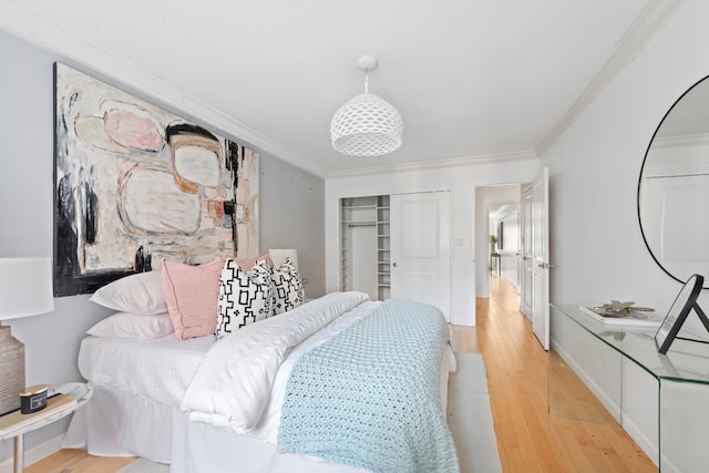 bedroom with crown molding, light wood-style floors, and a closet