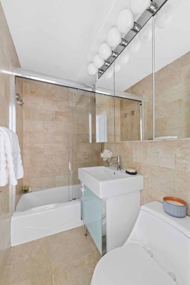 full bath with tile walls, toilet, combined bath / shower with glass door, and tile patterned flooring