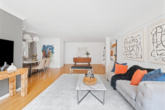 living room with crown molding and wood finished floors
