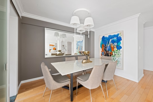 dining space with crown molding, light wood finished floors, and baseboards