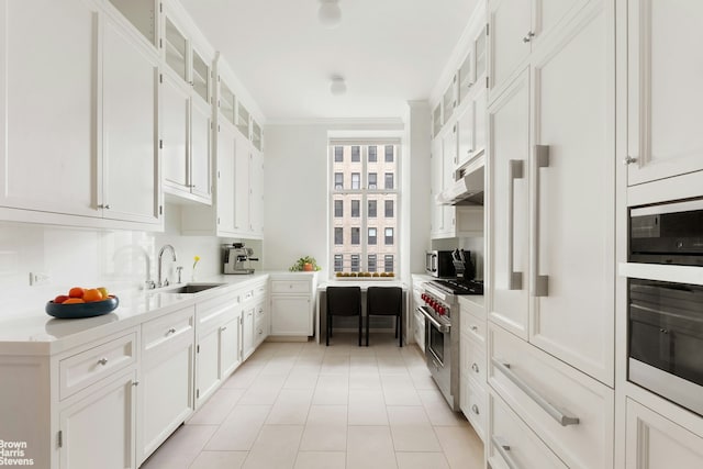 390 W End Ave Unit 5H, New York City, NY 10024 - kitchen featuring high end stainless steel range oven, a sink, white cabinets, light countertops, and ornamental molding