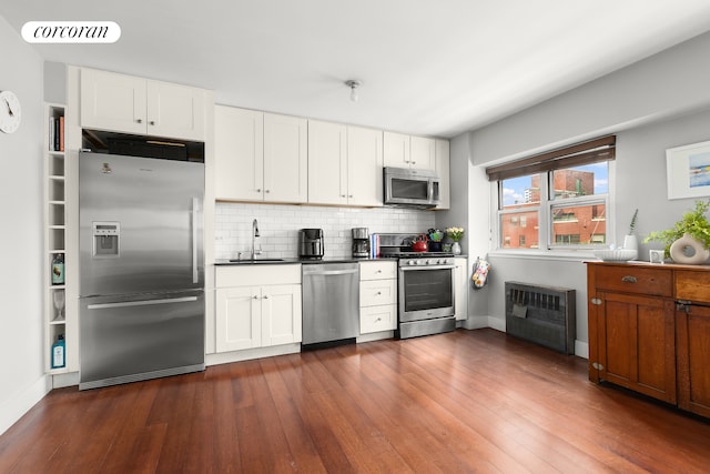 609 Columbus Ave Unit 14K, New York City, NY 10024 - kitchen featuring appliances with stainless steel finishes, a sink, tasteful backsplash, dark countertops, and dark wood-type flooring