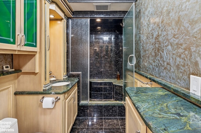 full bath with vanity, a stall shower, and granite floors