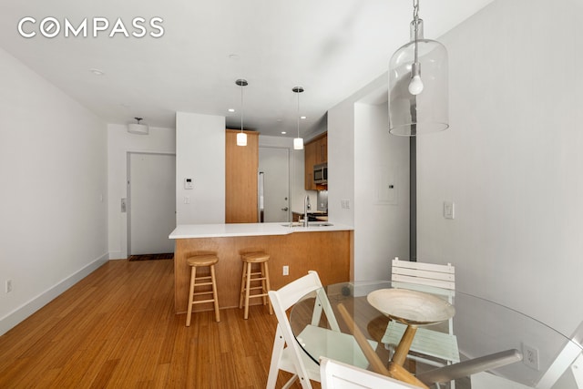 dining space with light wood-style floors, recessed lighting, and baseboards