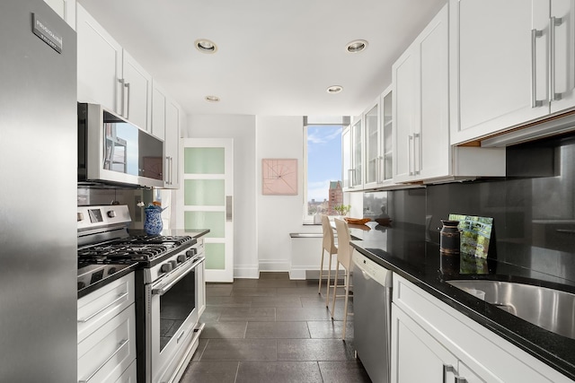 300 E 77th St Unit 30B, New York City, NY 10075 - kitchen featuring appliances with stainless steel finishes, baseboards, white cabinetry, recessed lighting, and glass insert cabinets