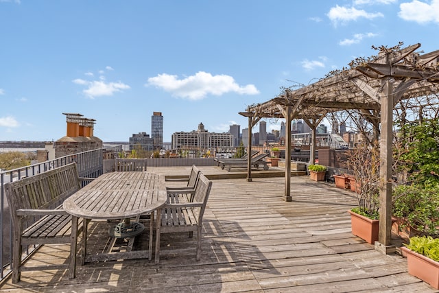 wooden deck with a pergola and outdoor dining space