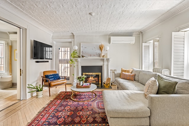 living area featuring an AC wall unit, hardwood / wood-style flooring, plenty of natural light, and ornamental molding