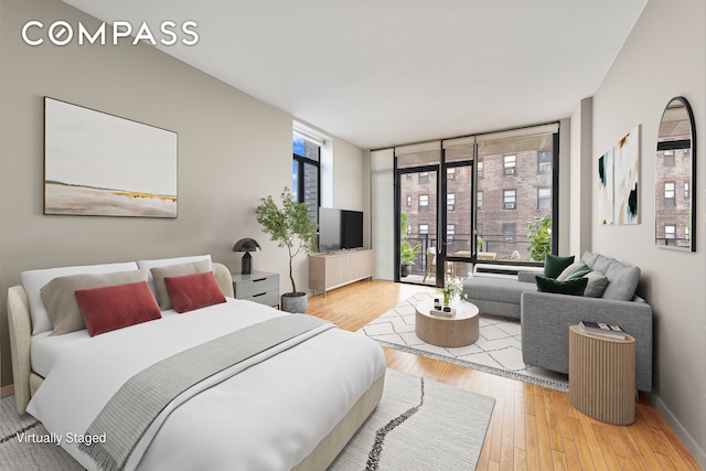 148 E 24th St Unit 12B, New York City, NY 10010 - bedroom featuring expansive windows, hardwood / wood-style floors, and radiator