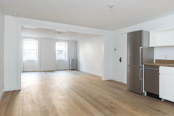 unfurnished living room featuring light wood-style floors, radiator, and baseboards