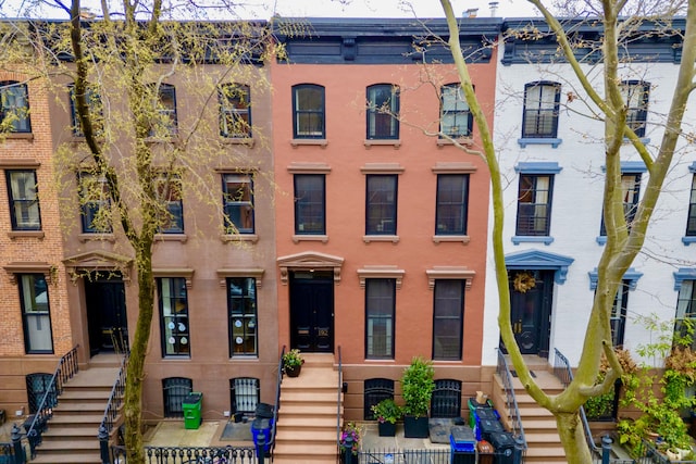view of property featuring stairs and a fenced front yard