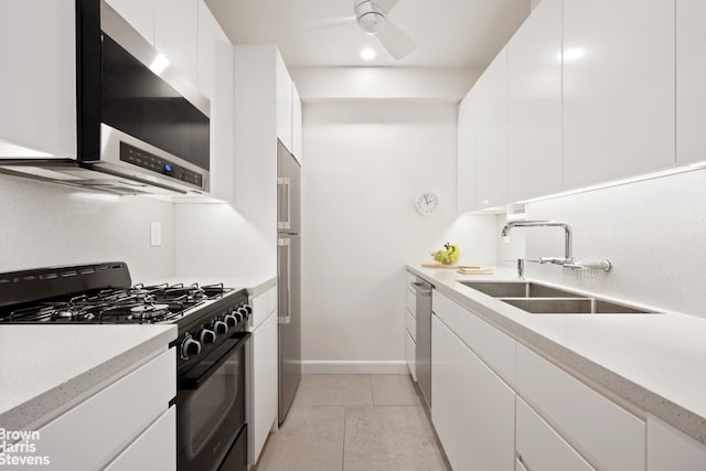 kitchen featuring black gas range oven, a sink, stainless steel dishwasher, range hood, and white cabinetry