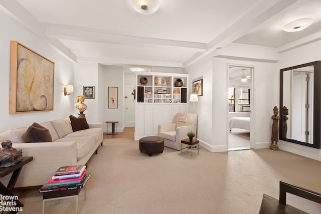 living area featuring beam ceiling, carpet flooring, and baseboards