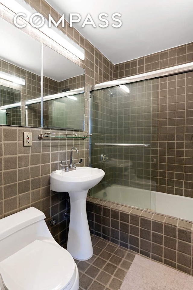 166 E 61st St Unit 7E, New York City, NY 10065 - bathroom with toilet, tile walls, tile patterned flooring, and tiled shower / bath combo