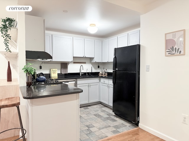420 Classon Ave Unit C, New York City, NY 11238 - kitchen with freestanding refrigerator, a peninsula, dark countertops, a breakfast bar area, and a sink