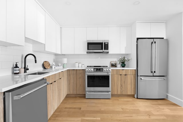 256 Putnam Ave Unit 1, New York City, NY 11216 - kitchen with appliances with stainless steel finishes, modern cabinets, tasteful backsplash, and light wood-type flooring