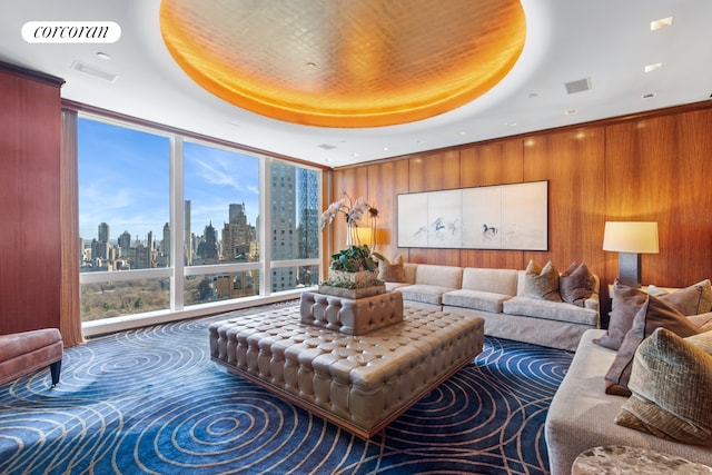 25 Columbus Cir Unit 56F, New York City, NY 10019 - living area featuring a view of skyline, healthy amount of natural light, a raised ceiling, wood walls, and expansive windows