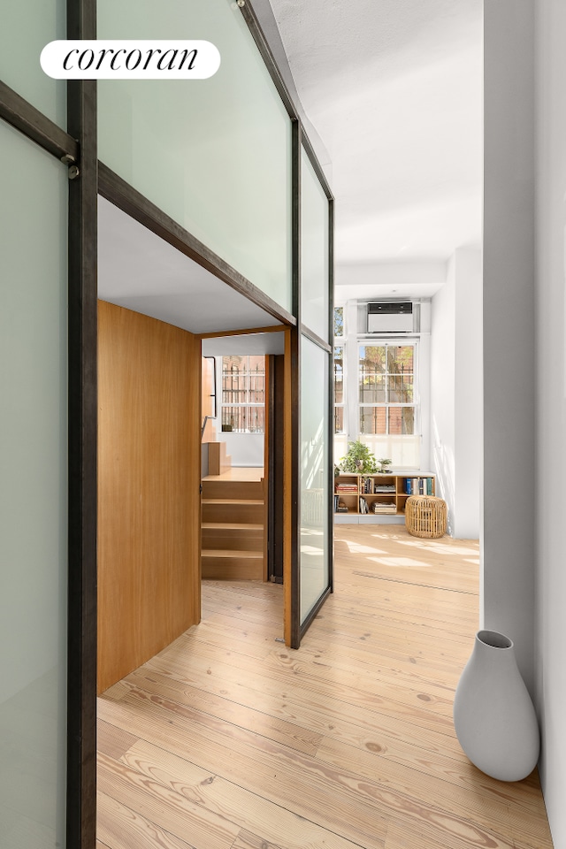 corridor featuring wood-type flooring and stairway